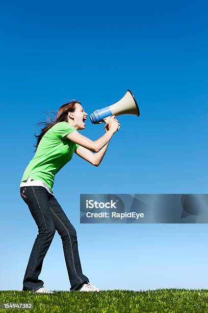 Pretty Brunette Yells Into Loud Hailer Against Blue Sky Stock Photo - Download Image Now