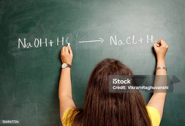 Una Ambidextro India Mujer Escribiendo En Greenboard Ecuación De Química Foto de stock y más banco de imágenes de Ácido