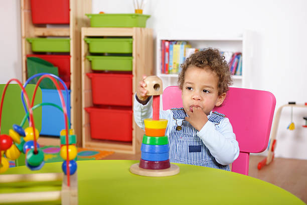 istock Toddler Sucking Fingers And Playing With Multi-Coloured Rings 154948051