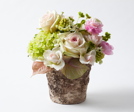 A pastel flower bouquet with roses and other flowers in pale pinks.