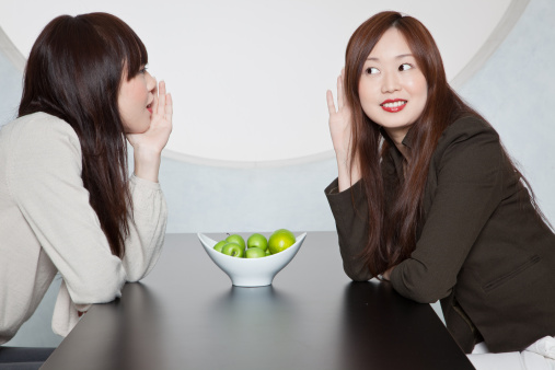 Two Japanese women having a conversation over a bowl of apples...