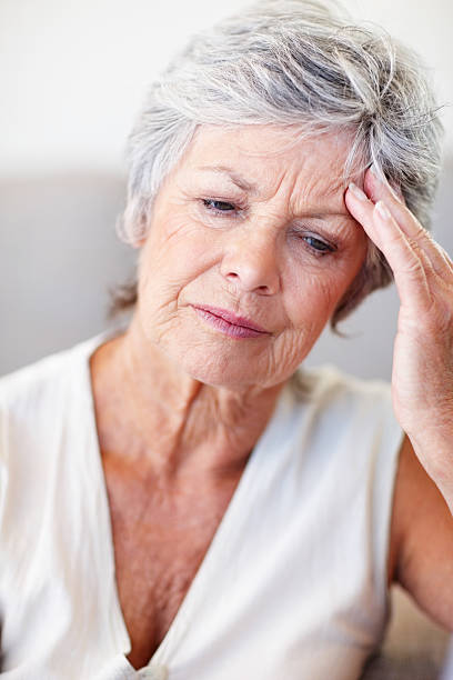 istock An elderly female holding her head in agony 154948678