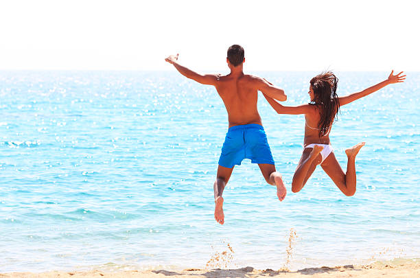 istock Happy couple  jumping on the beautiful beach. 154948703
