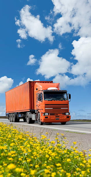 istock Blue sky over orange truck on highway transporting container 154948921