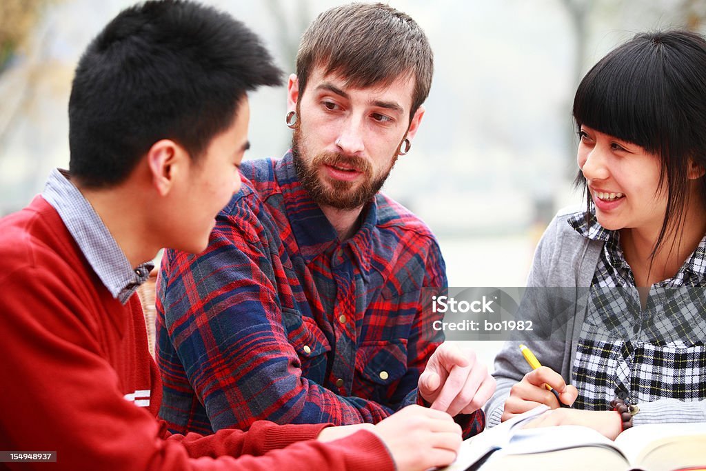 international communication two Chinese college students and one European student discussion together. 20-24 Years Stock Photo