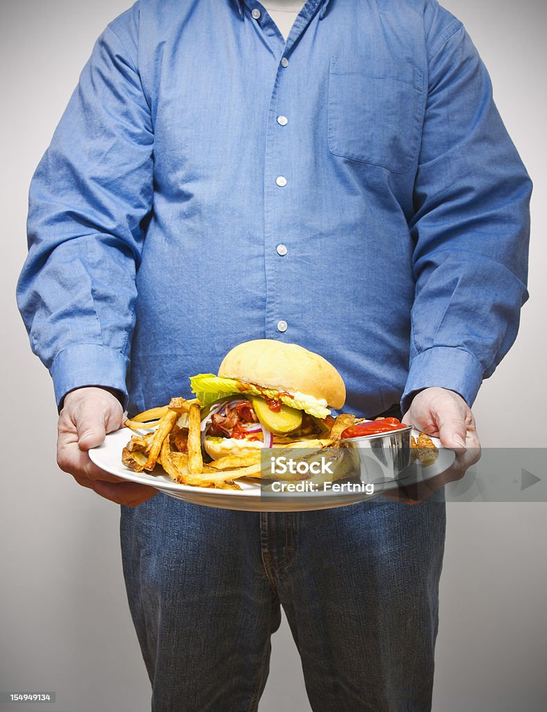 Surpoids homme tenant une grande assiette de nourriture frit - Photo de Surpoids libre de droits