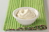 White bowl of cream cheese on green placemat