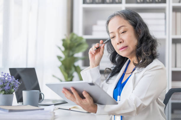 istock Happy senior woman surfing internet, checking email on digital tablet. 1549505089