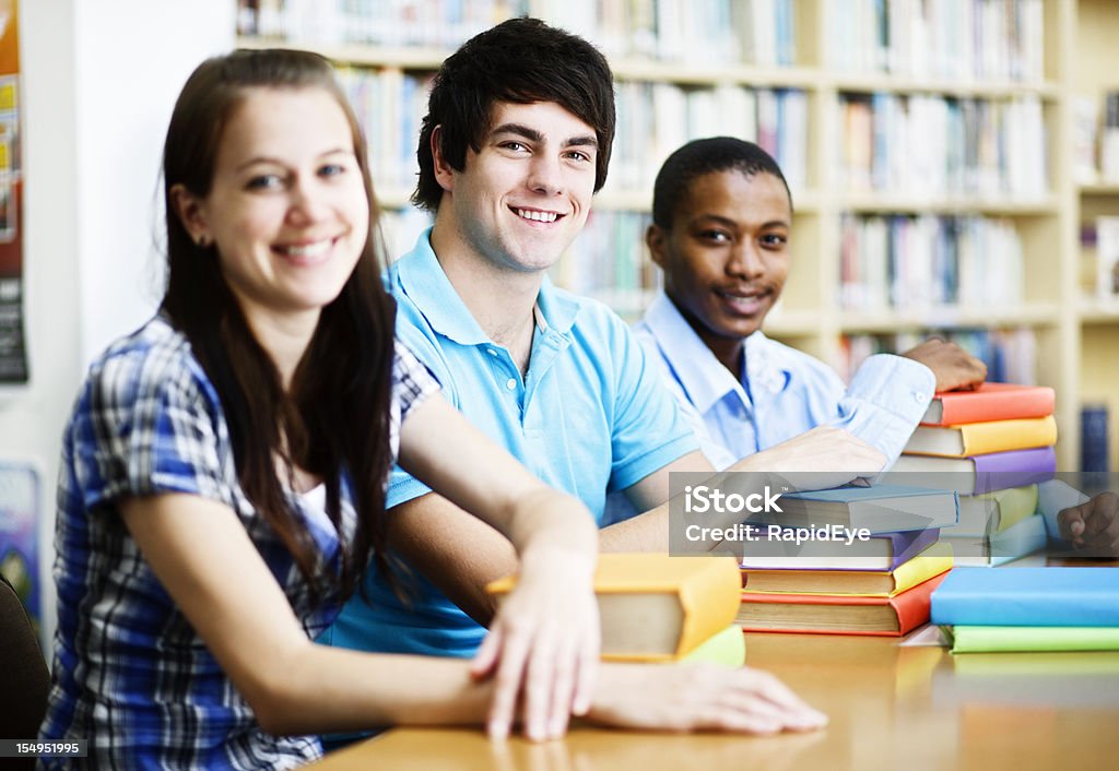 Três bom olhar sorridente estudantes partilhar uma biblioteca Mesa - Royalty-free 20-29 Anos Foto de stock