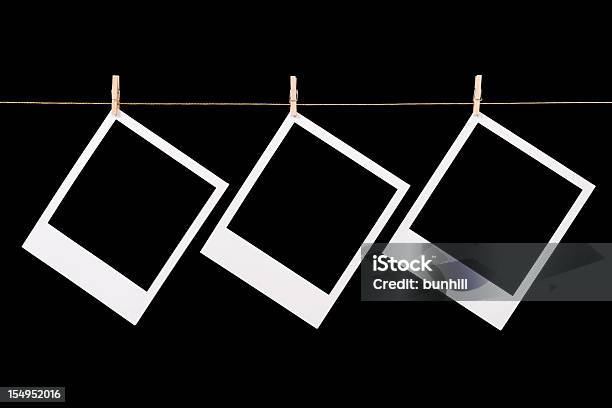 Три Blankedмгновенных Фотографий Polaroid Hanging — стоковые фотографии и другие картинки Мгновенная печать - Мгновенная печать, Чёрный фон, Вешать