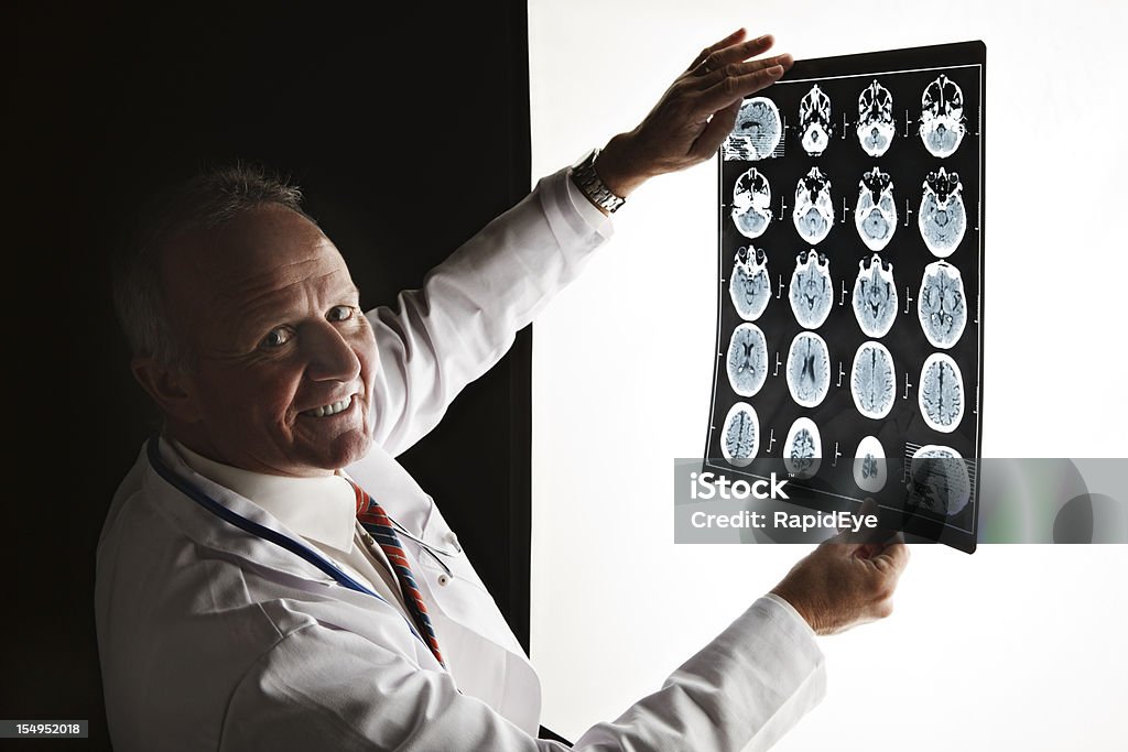 Doctor turns smiling from  CAT scan - good news!  Dark Stock Photo