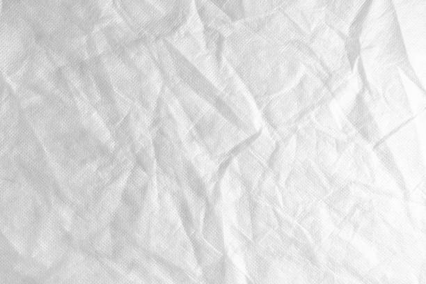 istock Wrinkled, crumpled white spunbond fabric texture background 1549521800
