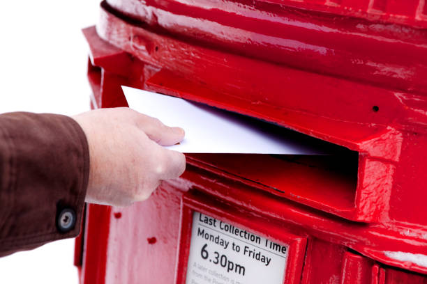 istock Man's hand posting letter in a snowy British postbox 154952184