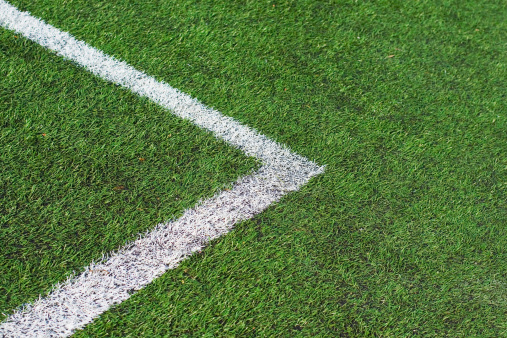 Corner on a football field close up photo. Field is made of artificial grass.