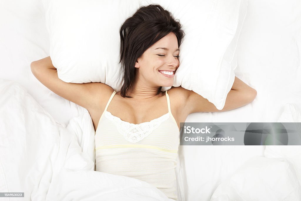 Radosny Młoda kobieta relaks na łóżku - Zbiór zdjęć royalty-free (Łóżko)