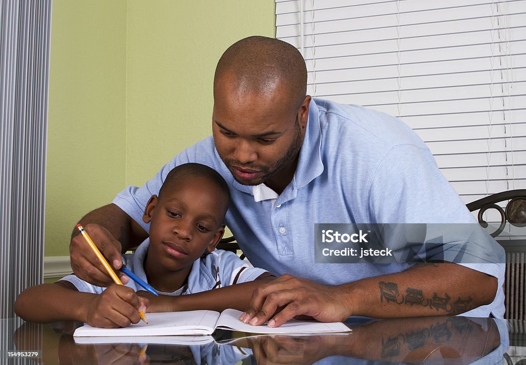 Père aider Son fils de faire ses devoirs - Photo de Bleu libre de droits