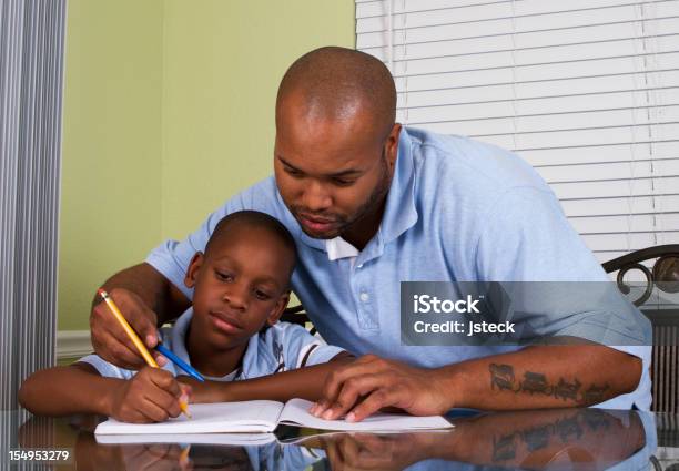 Photo libre de droit de Père Aider Son Fils De Faire Ses Devoirs banque d'images et plus d'images libres de droit de Bleu - Bleu, D'origine africaine, Faire ses devoirs