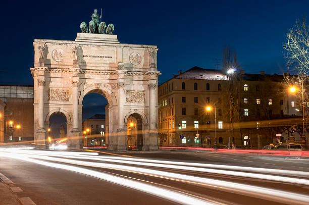 Munich Victory Gate Long exposure photograph of traffic at dusk passing the floodlit Victory Gate (Siegestor) in central Munich in Bavaria, Germany.  The structure was completed in 1852. siegestor stock pictures, royalty-free photos & images