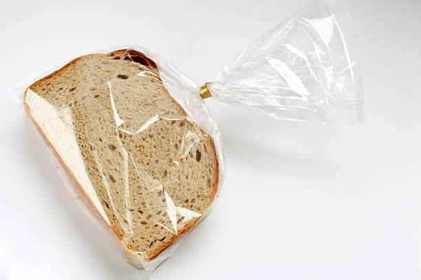 fatias frescas de pão em folie de plástico transparente em branco - graubrot - fotografias e filmes do acervo