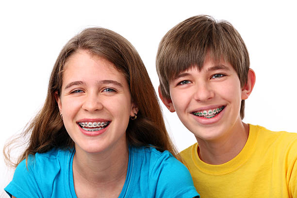 Young Girl And Boy With Braces XXXL.  Young girl and boy wearing braces on white. gchutka stock pictures, royalty-free photos & images