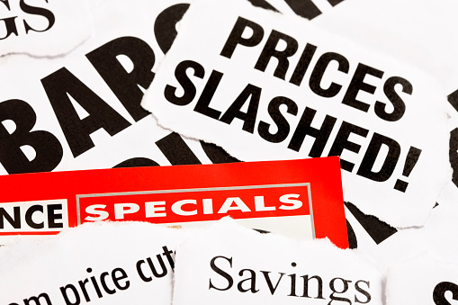 A large stack of newspaper cuttings, all dealing with slashed prices, bargains, and specials.  