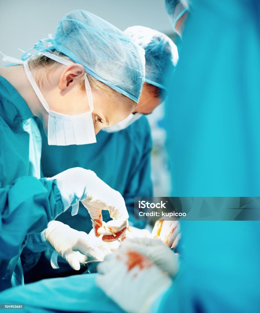 Femmina medico di eseguire l'intervento con il team - Foto stock royalty-free di Adulto