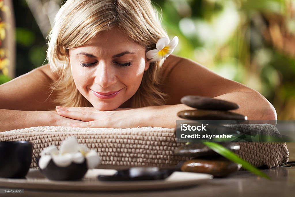 Mujer sonriente que reciben terapia de masajes en el spa - Foto de stock de Dar masajes libre de derechos