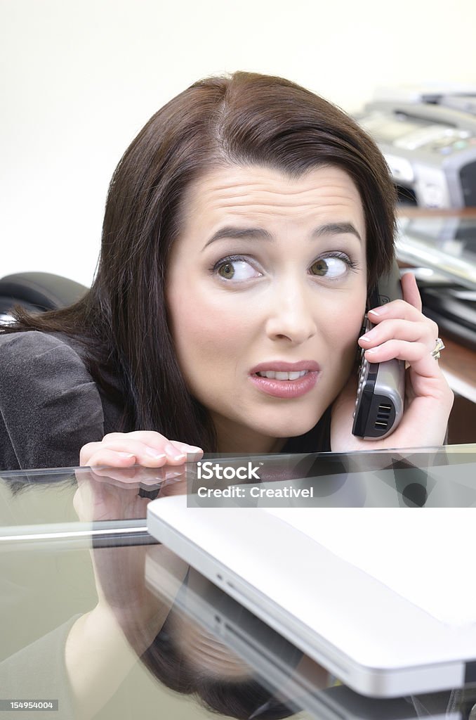 Gestresste Geschäftsfrau spricht am Telefon, Verstecken hinter der Rezeption - Lizenzfrei Betrachtung Stock-Foto