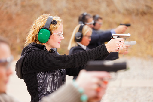 A group of people practicing at the gun range. Photographed on location at a shooting range.