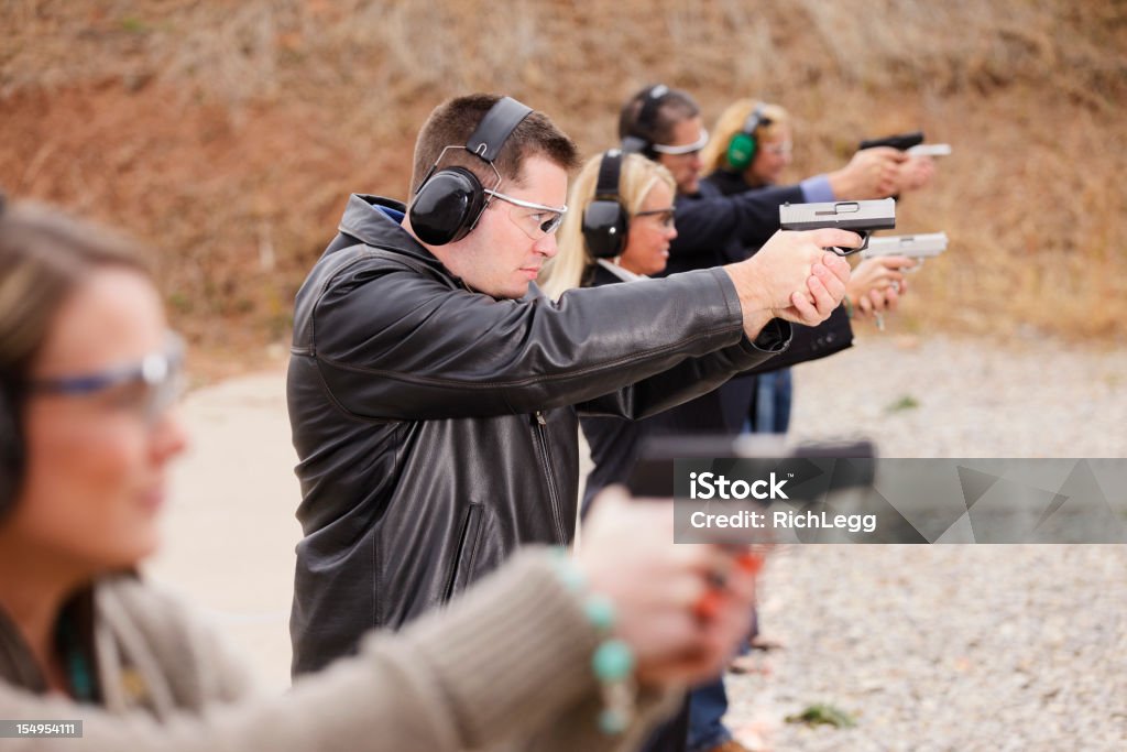 Practicing at the Shooting Range A group of people practicing at the gun range. Photographed on location at a shooting range. Target Shooting Stock Photo