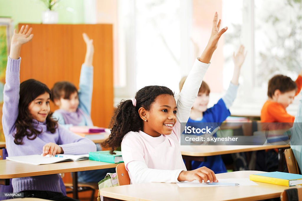 Enfants de répondre à la tâche en configuration salle de classe. - Photo de Lever la main libre de droits