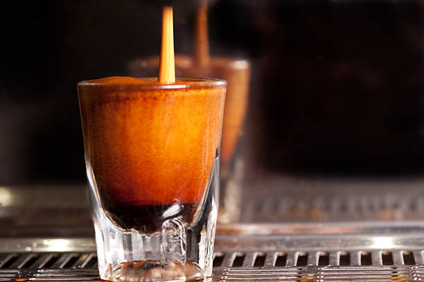 Espresso pouring into a shot glass on the coffee machine. stock photo