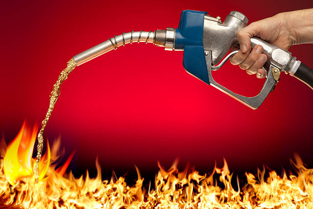 nourrir la flamme; putting essence sur le feu - gas station service red yellow photos et images de collection