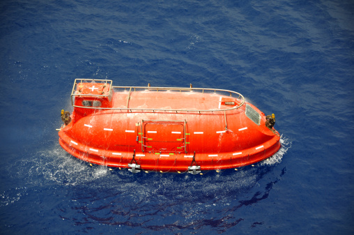 Life boat or rescue boat being tested in the open sea.  These type of boats are used in both the oil/gas and shipping industries.