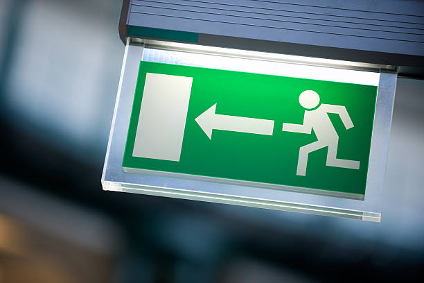 Emergency exit sign in white and green stock photo