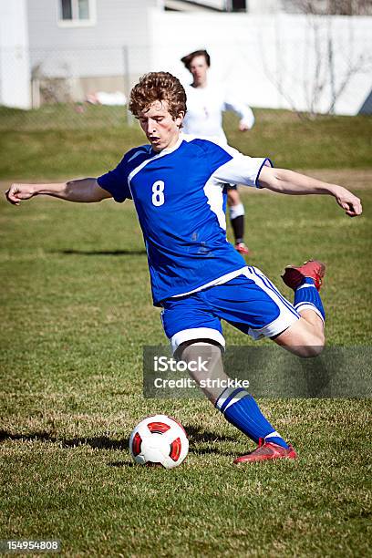 Photo libre de droit de Attrayant Homme Joueur De Football En Zone Bleue Souple Power Kick banque d'images et plus d'images libres de droit de Activité