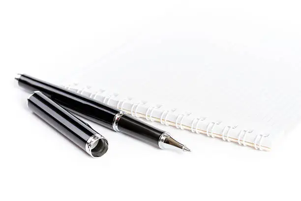 notepad with ballpen on white background