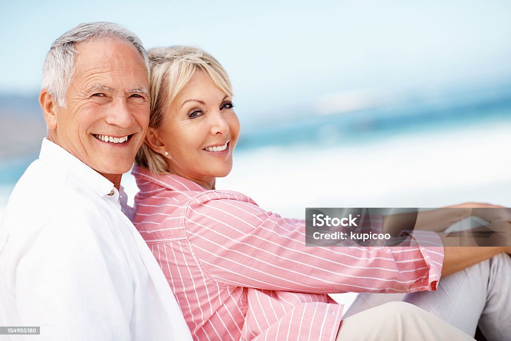 Couple relaxing on beach Senior couple enjoying summer vacation on the beach - copyspace Senior Couple Stock Photo