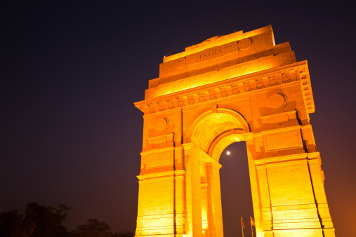 Illuminated famous India Gate in New Delhi, India, at dusk. The India Gate is the national monument of India. Originally known as All India War Memorial, it is a landmark in Delhi and commemorates the soldiers of the British Indian Army who lost their lives while fighting for the British Indian Empire in World War I and the Third Anglo-Afghan War. It was built of red sand stone and granite. 