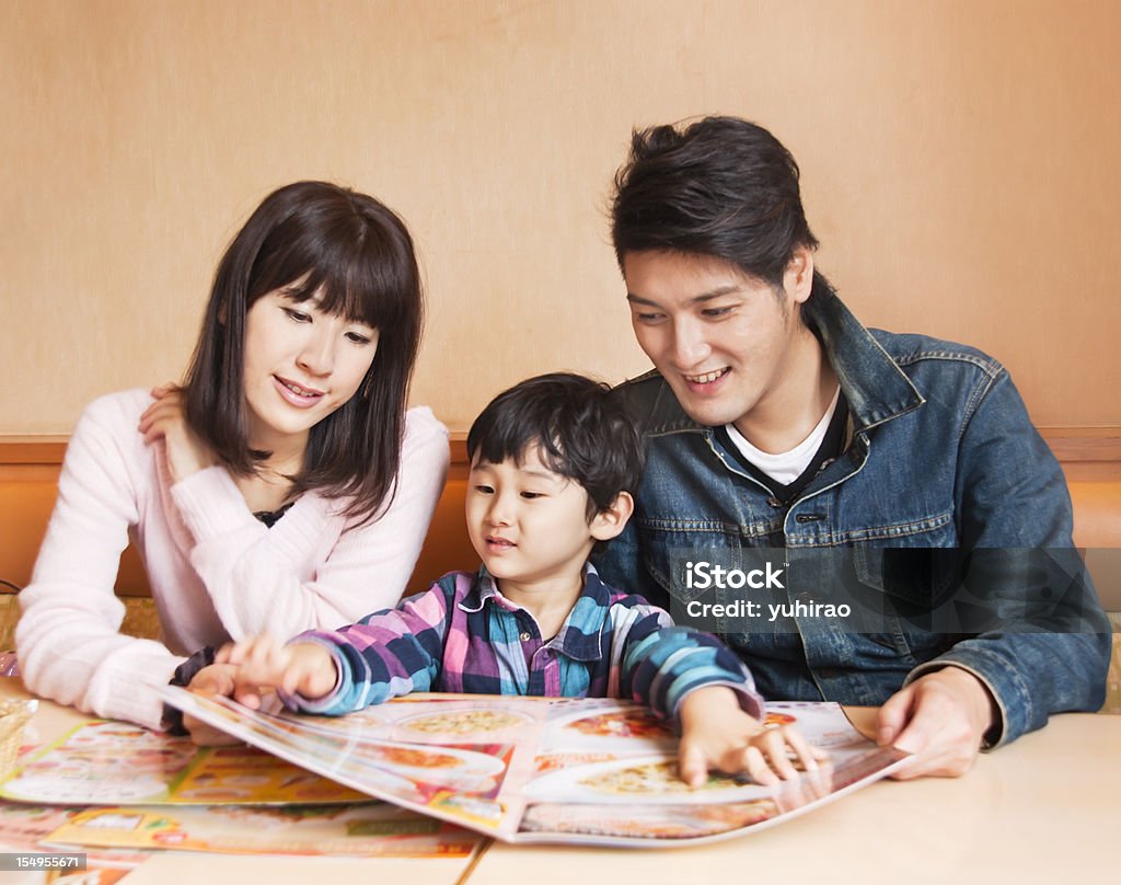 Famiglia asiatica, guardare un menu del ristorante - Foto stock royalty-free di Ristorante