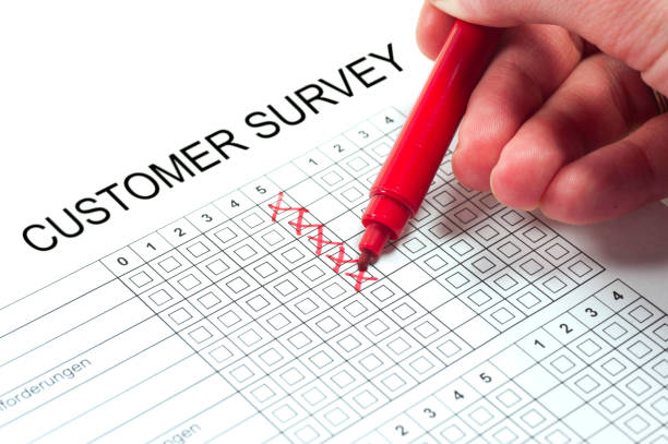 customer survey with hand and pen customer satisfaction paper with human hand and red pencustomer satisfaction paper with human hand and red pen umfrage stock pictures, royalty-free photos & images