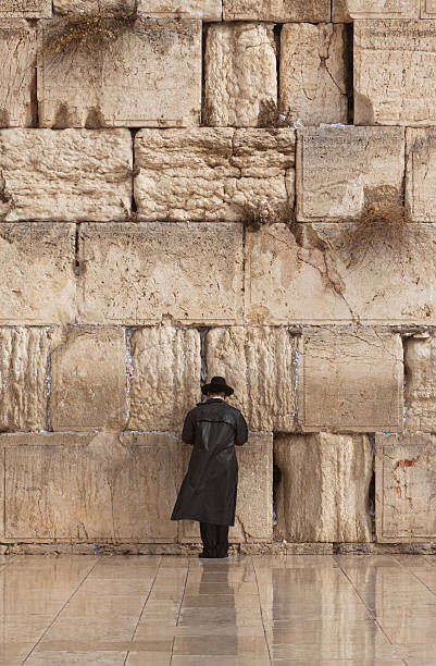 Jewish man praying on the Wailing Wall in Jerusalem Orthodox Jewish man praying alone at the Wailing Wall in Jerusalem, Israel. wailing wall stock pictures, royalty-free photos & images