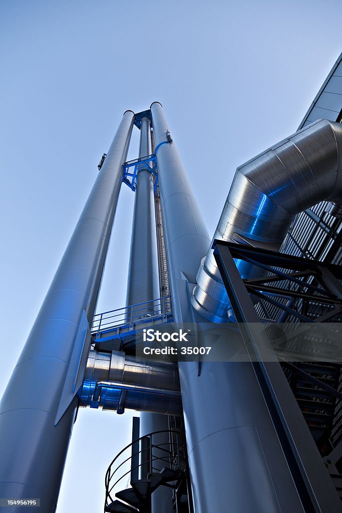 industry power pipes industrial tower of power metal chic. illuminated blue lights. Built Structure Stock Photo