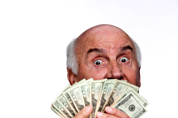 istock Senior gentleman holding stack of dollars in front of him 154956315