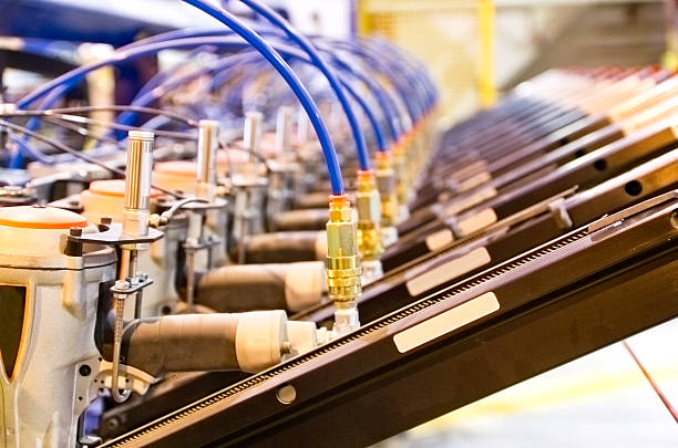 Industrial background image of a gang of pneumatic nailers fixtured on an industrial machine in a wood working factory.