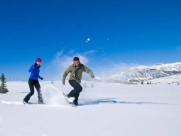 invierno de pareja en el exterior del hotel - winter snowshoeing running snowshoe fotografías e imágenes de stock