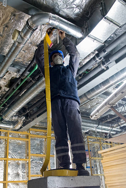 istock Hard worker wrapping an HVAC Air duct with foil tape 154957049