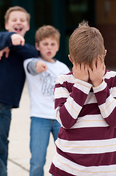 scuola elementare di bullismo verticale - bullying child teasing little boys foto e immagini stock