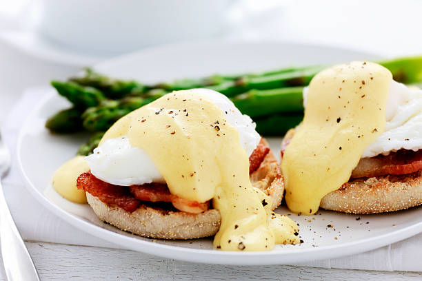 Eggs Benedict Eggs Benedict with a side of asparagus. hollandaise sauce stock pictures, royalty-free photos & images