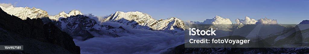 Nieve Cumbre panorama del atardecer las montañas por encima de las nubes Himalayas Nepal - Foto de stock de Acantilado libre de derechos